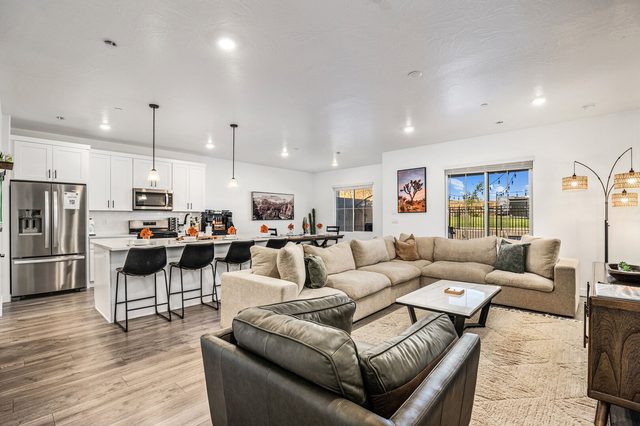 Open living room with sectional sofa and kitchen island behind