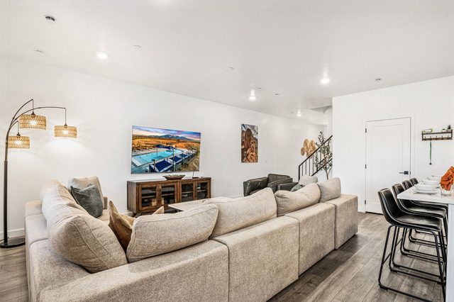 Deep sectional sofa with TV and staircase in view