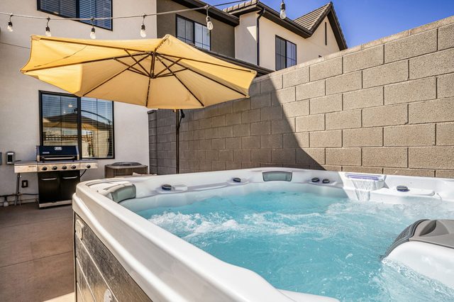 Private hot tub bubbling beside the patio grill