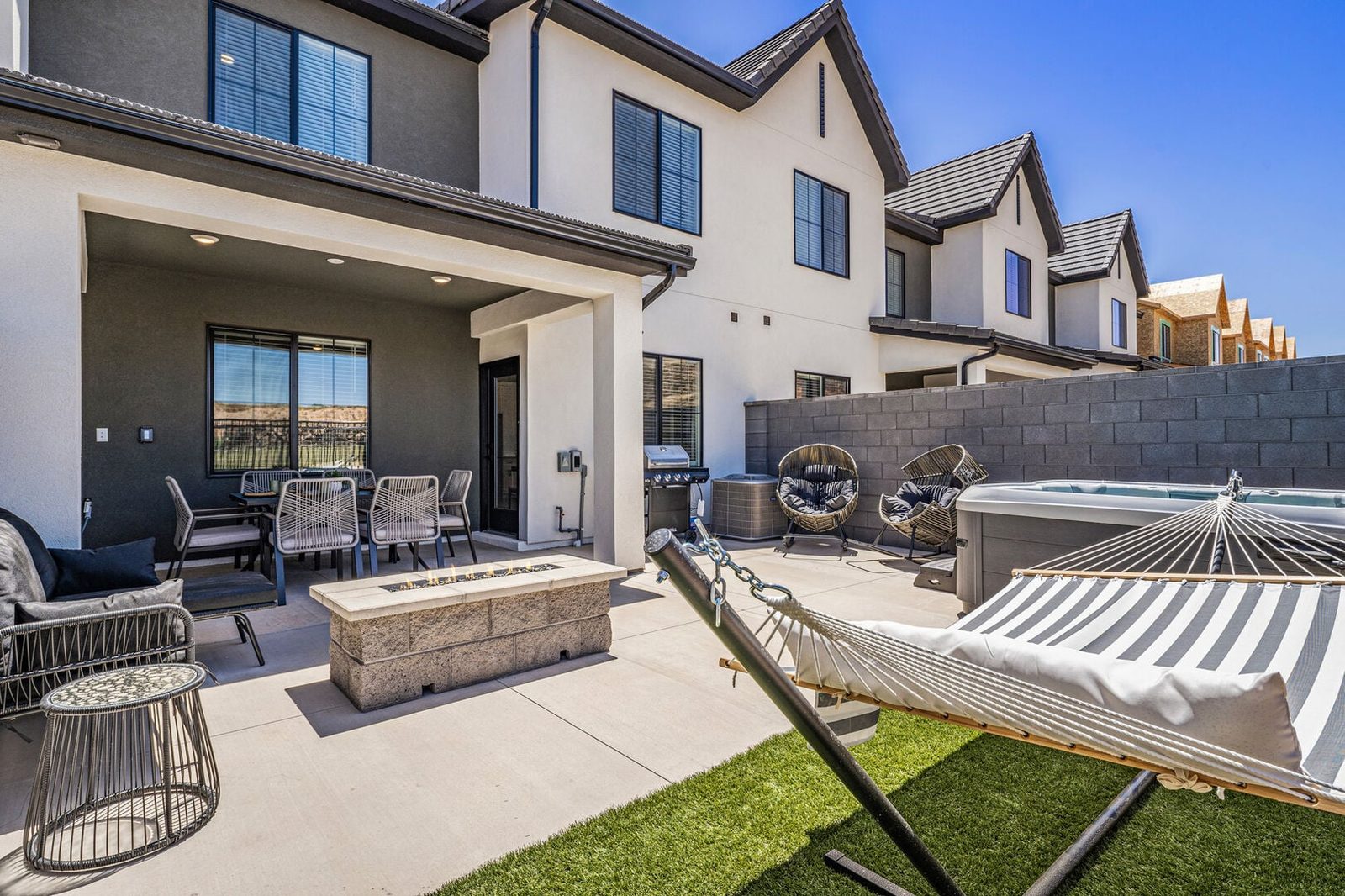 Fenced backyard with hammock, fire table and hot tub at Skyline 1682