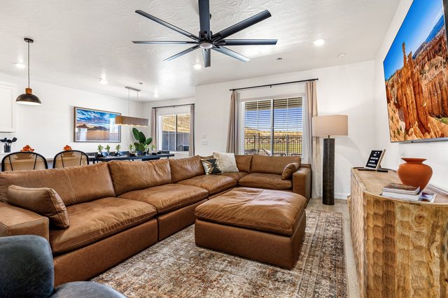Leather sectional and ottoman under ceiling fan in the living room