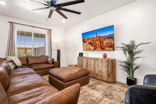 Large leather sectional facing wall-mounted smart TV in living room
