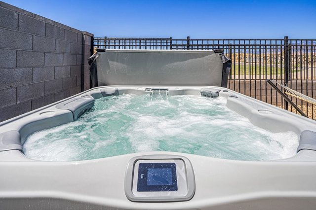 Bubbling private hot tub inside the fenced backyard
