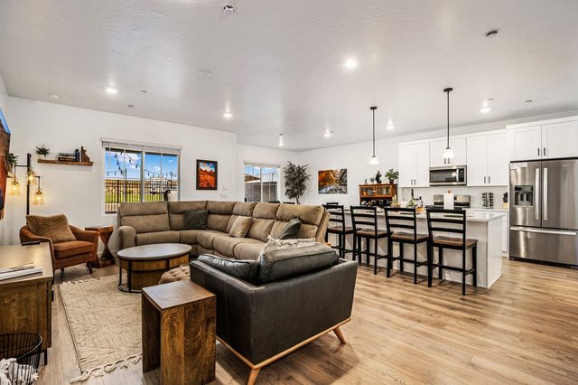 Open living room with reclining sectional and kitchen beyond