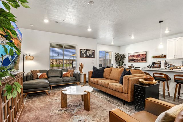 Open living room with leather sofas and kitchen bar seating