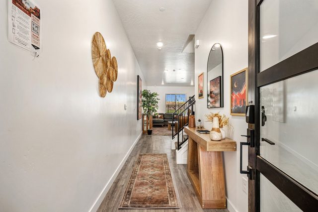 Entry hallway with wood console and runner rug at Skyline 1690
