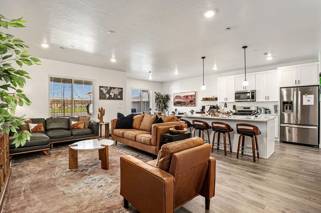 Great room with leather sofas open to the white kitchen