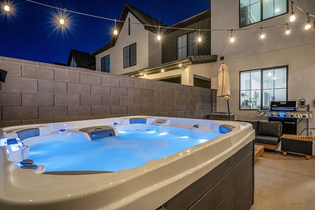 Private seven-person hot tub lit blue at Skyline 1690