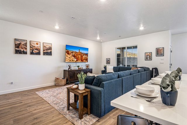 Living room sectional facing smart TV beside the dining area