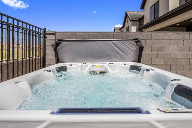 Bubbling private hot tub inside the fenced backyard