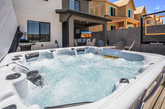 Private hot tub with covered patio and outdoor TV behind