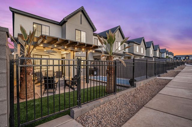 Rear exterior with fenced backyard and pergola at sunset