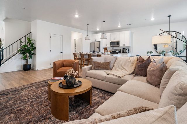 Living room sectional with staircase and kitchen in the background
