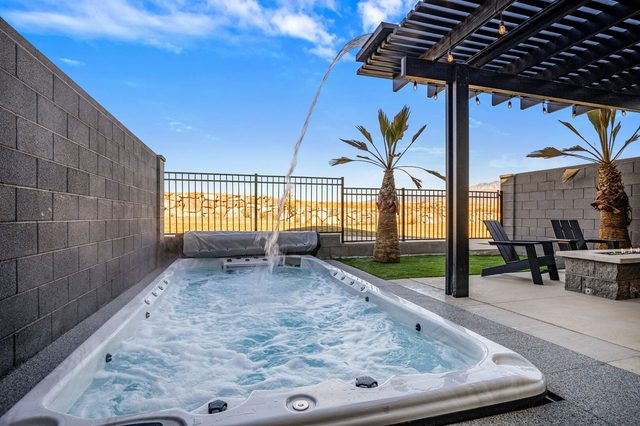 Private swim spa with water feature and desert hill views