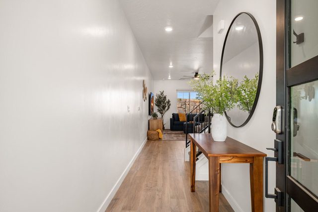 Entry hallway with console table and round mirror leading to living room