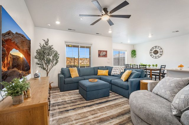 Living room with large sectional sofa, swivel chair and dining beyond