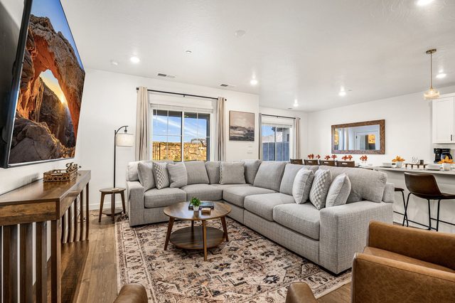 Main living room with large sectional sofa and smart TV