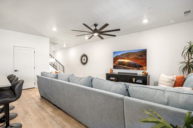 Living room with sectional, bar stools and staircase at Skyline 1729