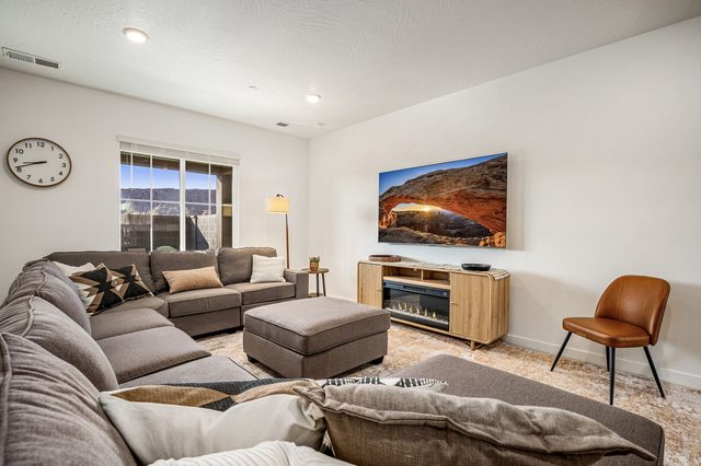 Living room with large sectional sofa, fireplace and wall TV