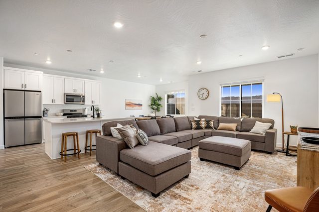 Open-concept great room with sectional sofa and kitchen behind