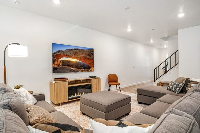 Living room with sectional, ottomans, fireplace and mounted TV