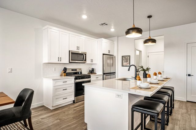Kitchen island with four stools and stainless appliances
