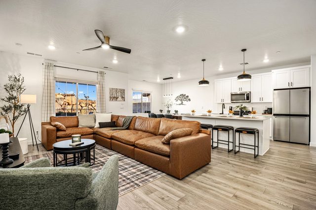 Open living room with leather sectional flowing into the kitchen
