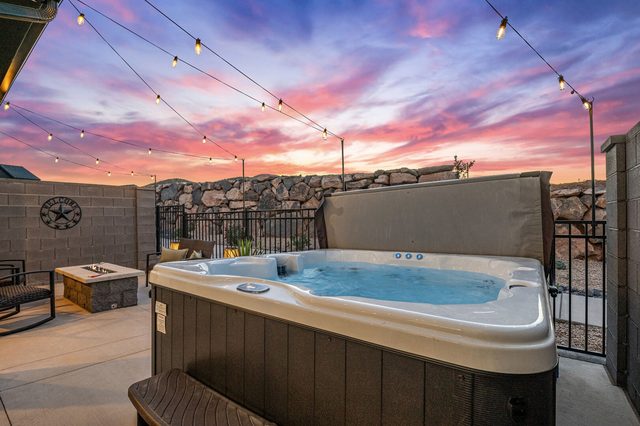 Private hot tub under string lights at sunset