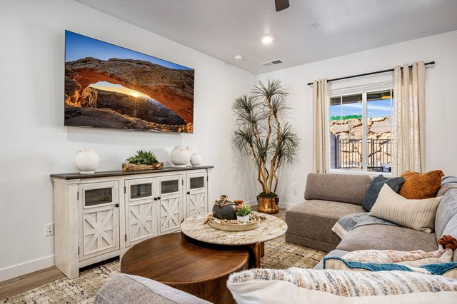 Living room with sectional, round coffee tables and TV