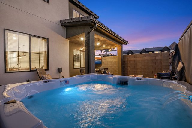 Private hot tub lit at dusk behind the townhome