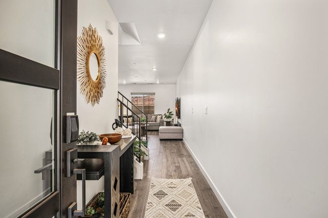 Front entry hallway with sunburst mirror and wood floors