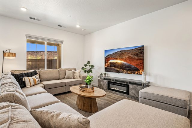 Sectional sofa facing a large TV and electric fireplace console
