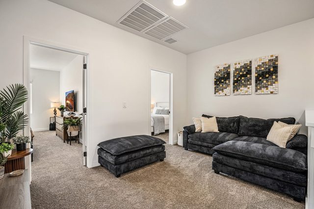 Upstairs loft with dark velvet sectional and ottoman