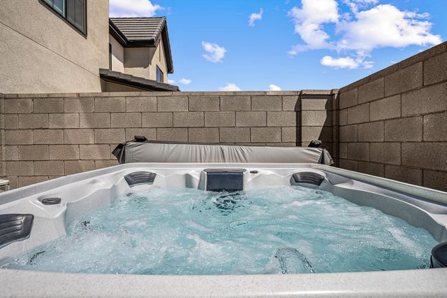 Bubbling private hot tub against the backyard block wall