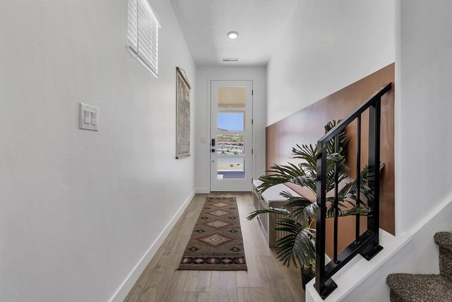 Front entry hallway with runner rug and staircase