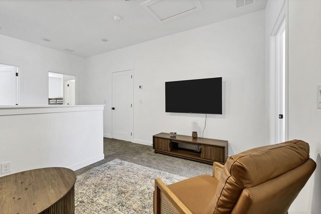 Upstairs loft with recliner chair and wall-mounted TV