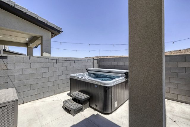 Private hot tub with steps in the walled back patio