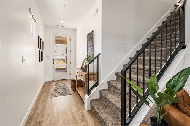 Main floor hallway beside the carpeted staircase with black railing