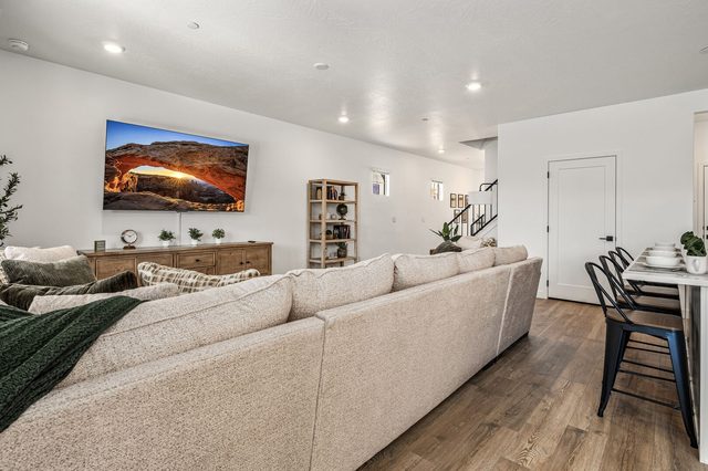 Large beige sectional facing the living room TV and bookshelf