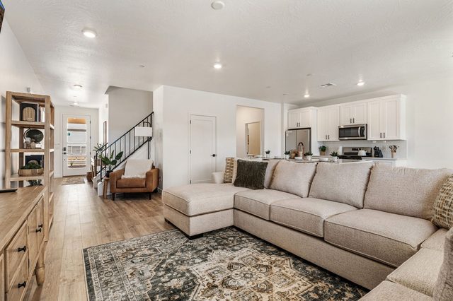 Living area sectional with view toward the kitchen and stairs