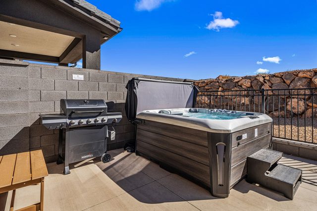 Private hot tub next to the gas grill in the backyard