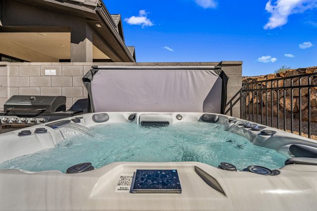 Private hot tub with red rock boulders behind the fence