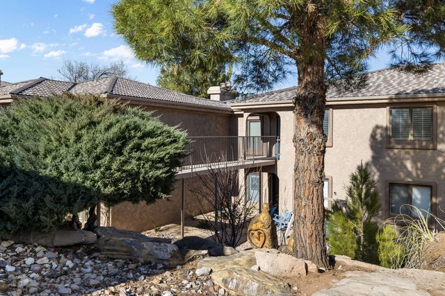 Condo building exterior with pine tree and landscaping