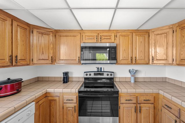 Kitchen with wood cabinets, stainless range and microwave