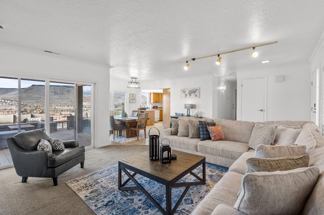 Living room with sectional and armchair opening to the dining area