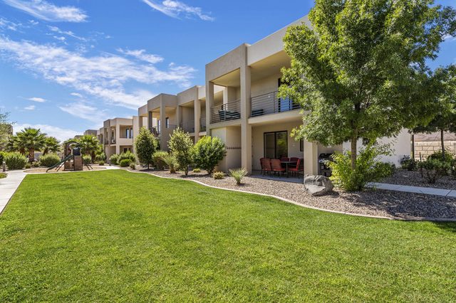 Rear exterior of the townhomes facing a shared green lawn