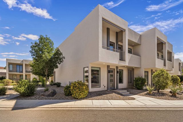 Street view of the contemporary townhome with desert landscaping