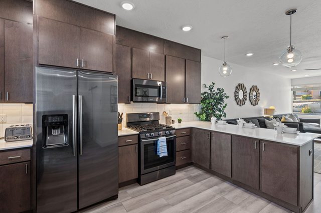 Kitchen with stainless appliances opening to the living room
