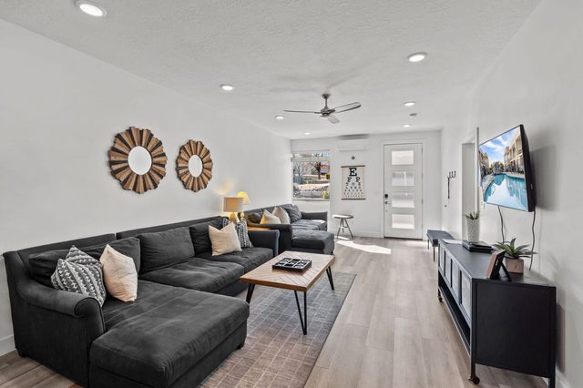 Living room with large sectional sofa and wall TV at The Lofts 2