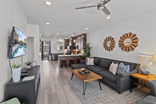 Living area sectional and coffee table flowing into the kitchen bar